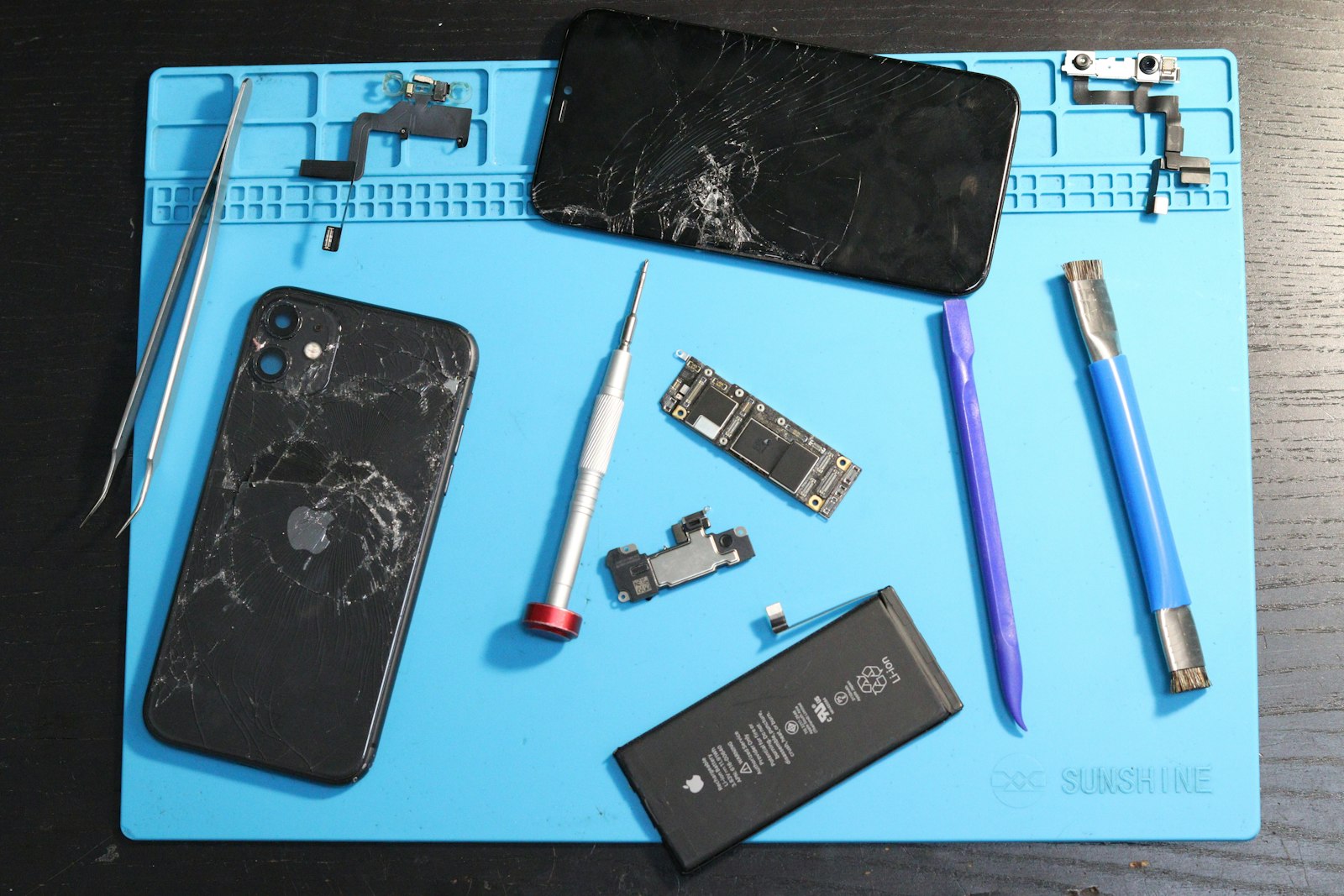 Telefon deschis pe un covor de service, cu unelte (imagine ilustrativă)